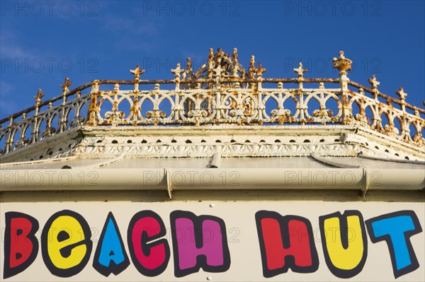 ENGLAND, East Sussex, Brighton, Beach hut sign above shop at the promenade end of the former West Pier.