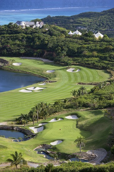 WEST INDIES, St Vincent & The Grenadines, Canouan, "Raffles Resort Trump International Golf Course designed by Jim Fazio. The 16th green which is the longest par 3 in the world, the 17th fairway with the resort and coral reef beyond"