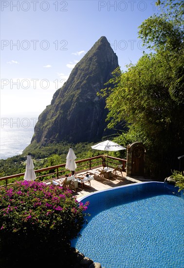 WEST INDIES, St Lucia, Soufriere , Val des Pitons Tourists sunbathing on the sun deck beside the pool at Ladera Spa Resort Hotel overlooking Petit Piton volcanic plug and Jalousie beach