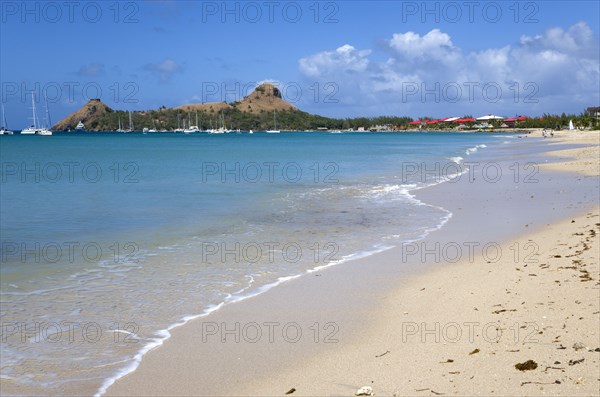 WEST INDIES, St Lucia, Gros Islet , Pigeon Island National Historic Park seen from a nearby beach on a causeway to the island with yachts at anchor in Rodney Bay