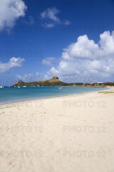 WEST INDIES, St Lucia, Gros Islet , Pigeon Island National Historic Park seen from a nearby beach on a causeway to the island with yachts at anchor in Rodney Bay