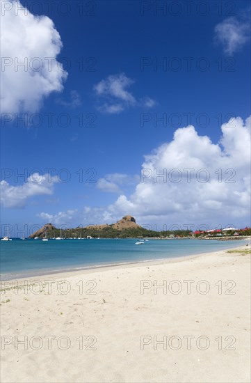 WEST INDIES, St Lucia, Gros Islet , Pigeon Island National Historic Park seen from a nearby beach on a causeway to the island with yachts at anchor in Rodney Bay