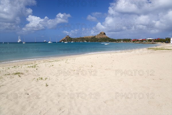 WEST INDIES, St Lucia, Gros Islet , Pigeon Island National Historic Park seen from a nearby beach on a causeway to the island with yachts at anchor in Rodney Bay