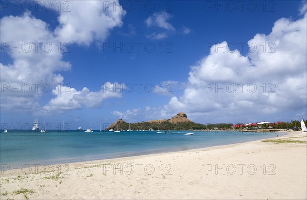 WEST INDIES, St Lucia, Gros Islet , Pigeon Island National Historic Park seen from a nearby beach on a causeway to the island with yachts at anchor in Rodney Bay