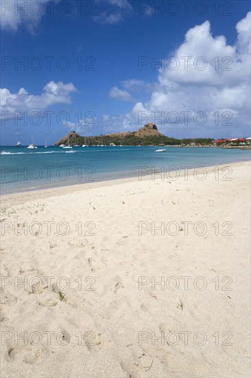 WEST INDIES, St Lucia, Gros Islet , Pigeon Island National Historic Park seen from a nearby beach on a causeway to the island with yachts at anchor in Rodney Bay