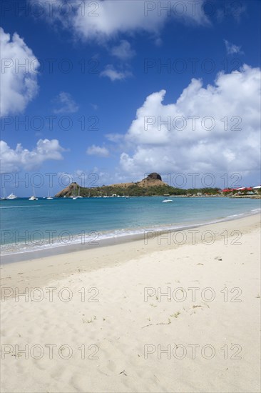 WEST INDIES, St Lucia, Gros Islet , Pigeon Island National Historic Park seen from a nearby beach on a causeway to the island with yachts at anchor in Rodney Bay