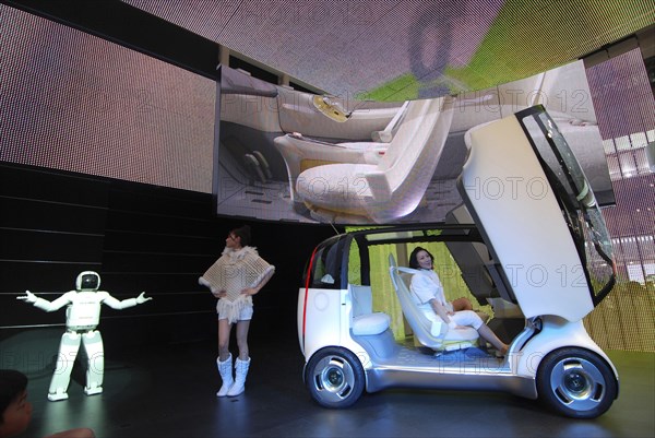 JAPAN, Honshu, Chiba, "2007 Tokyo Car Show, Honda exhibit, Asimo Robot presents the Honda concept car Puyo, young women assist, cars gull wing doors open"