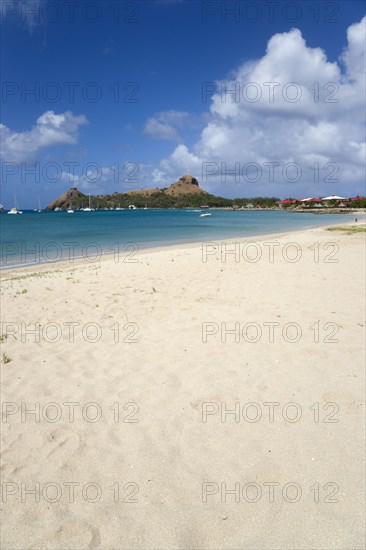 WEST INDIES, St Lucia, Gros Islet , Pigeon Island National Historic Park seen from a nearby beach on a causeway to the island with yachts at anchor in Rodney Bay