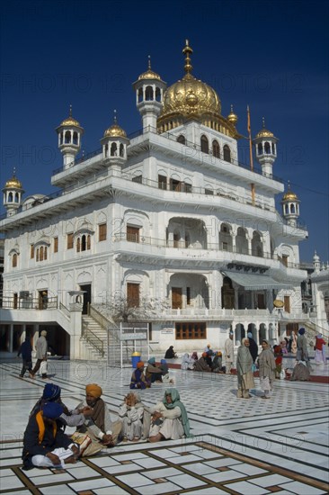 INDIA, Punjab, Amritsar, The Sri Akal Takhat Sahib Sikh Parliment building in the Golden Temple with groups of people gathered outside