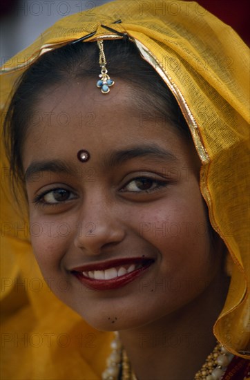 INDIA, Rajasthan, Alwar, Head and shoulders portrait of a young girl smiling at the Alwar Utsav Festival