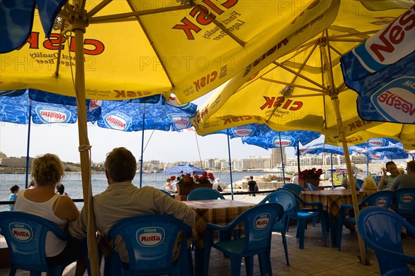 MALTA, Valletta, Passengers waiting for the ferry to Sliema under sunshade umbrellas on the waterfront