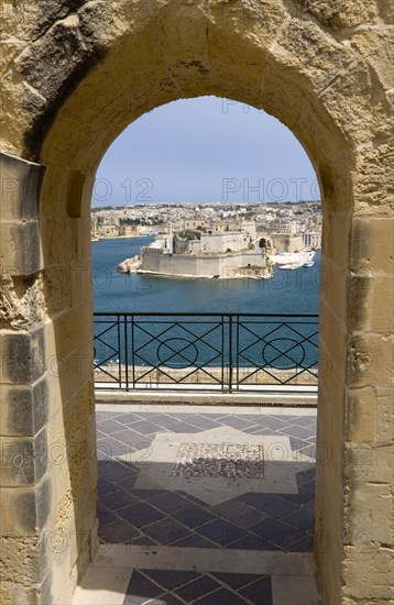 MALTA, Valletta, Fort Saint Angelo on Vittoriosa one of the Three Cities in Valletta Harbour seen through an arch in the Upper Barrakka Gardens in Valletta