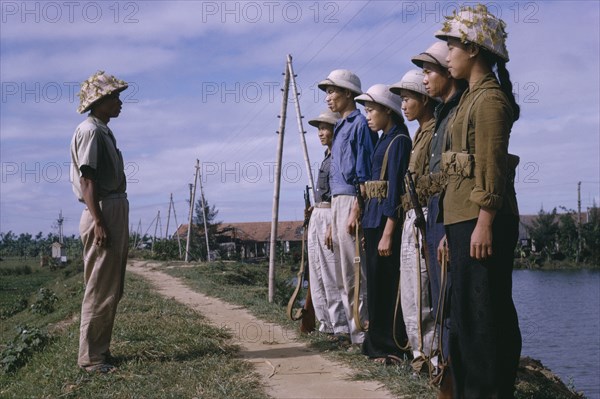VIETNAM, North , War, Line of male and female Viet Cong soldiers standing in front of superior officer