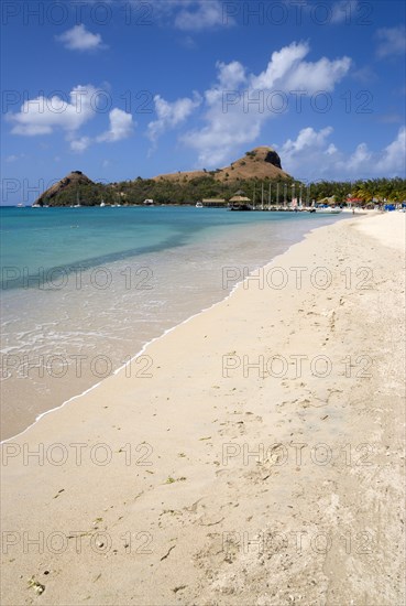 WEST INDIES, St Lucia, Gros Islet , The beach at Sandals Grande St Lucian Spa and Beach Resort hotel with Pigeon Island National Historic Park beyond