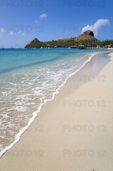WEST INDIES, St Lucia, Gros Islet , The beach at Sandals Grande St Lucian Spa and Beach Resort hotel with Pigeon Island National Historic Park beyond