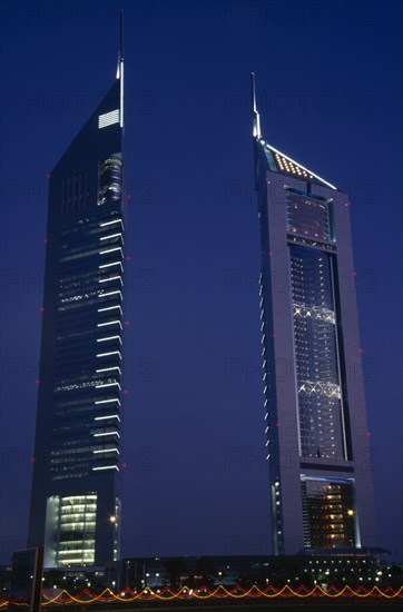 UAE, Dubai , Emirates Tower illuminated at night with coloured lights in the foreground.