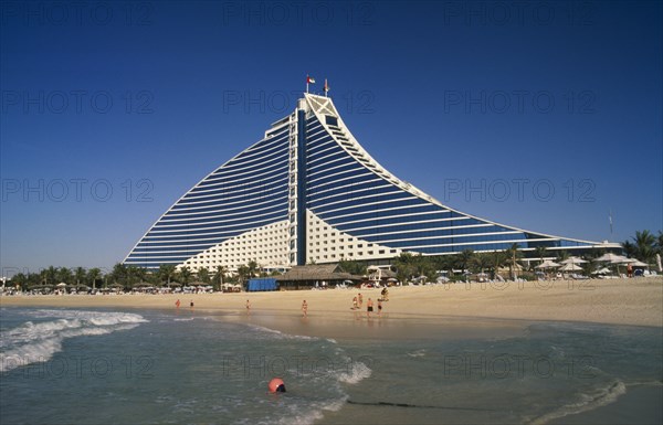 UAE, Dubai , Jumeirah Beach Hotel with people on private beach in foreground.