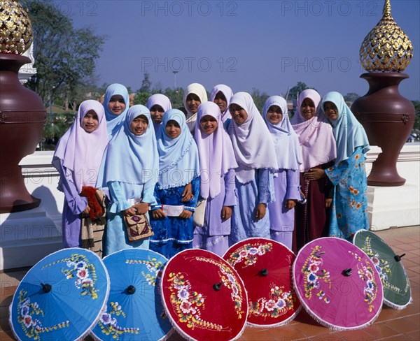 THAILAND, North, Chiang Mai, "Group of young Muslim Thai women standing behind blue, red, pink and green painted parasols at the Royal Flora Expo."