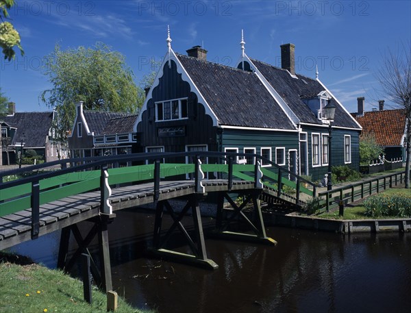 HOLLAND, Noord Holland, Zaanse Schans, Footbridge leading to a typical green wooden house in the village