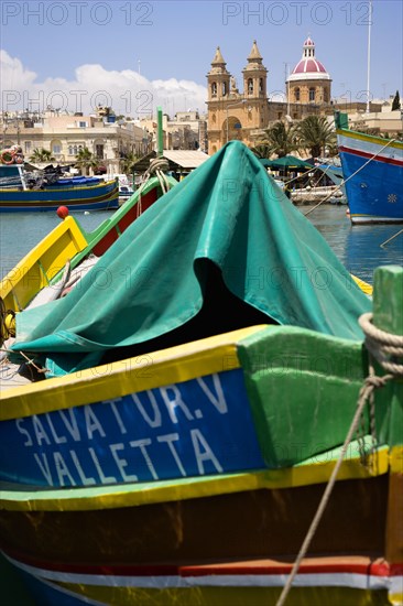 MALTA, Marsaxlokk , Fishing village harbour on the south coast with colourful Kajjiki fishing boats and the Church dedicated to Our Lady of the Rosary The Madonna of Pompeii