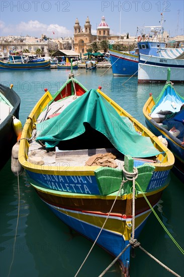 MALTA, Marsaxlokk , Fishing village harbour on the south coast with colourful Kajjiki fishing boats and the Church dedicated to Our Lady of the Rosary The Madonna of Pompeii