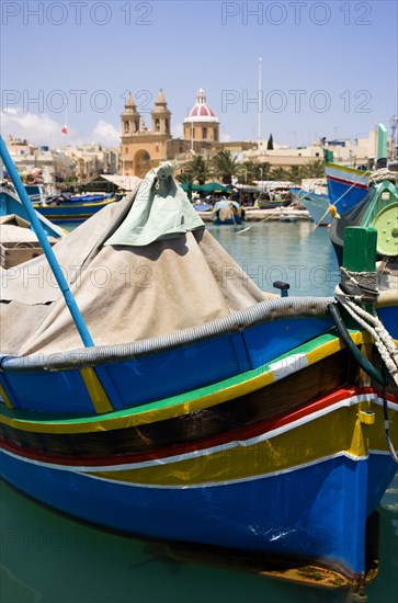 MALTA, Marsaxlokk , Fishing village harbour on the south coast with colourful Kajjiki fishing boats and the Church dedicated to Our Lady of the Rosary The Madonna of Pompeii