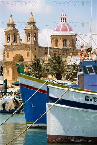 MALTA, Marsaxlokk , Fishing village harbour on the south coast with colourful fishing boats and the Church dedicated to Our Lady of the Rosary The Madonna of Pompeii