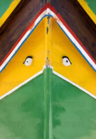 MALTA, Marsaxlokk , Fishing village harbour on the south coast with colourful Kajjiki fishing boat with the Eyes of Osiris on the bow