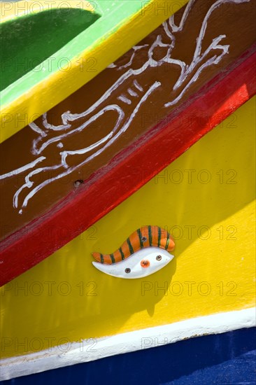 MALTA, Marsaxlokk , Fishing village harbour on the south coast with colourful Kajjiki fishing boat with the Eyes of Osiris on the bow