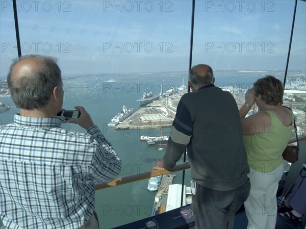 ENGLAND, Hampshire, Portsmouth, "Gunwharf Quays. The Spinnaker Tower. Interior with visitors looking out of glass windows on the top observation deck, providing a 320° view of the city of Portsmouth, the Langstone and Portsmouth harbours, and a viewing distance of 37 kilometres (23 miles)"