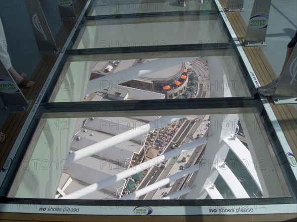 ENGLAND, Hampshire, Portsmouth, Gunwharf Quays. The Spinnaker Tower. Interior view looking down from observation deck through glass window towards the base of the tower over waterfront restaurants and shops.