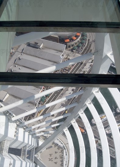 ENGLAND, Hampshire, Portsmouth, Gunwharf Quays. The Spinnaker Tower. Interior view looking down from observation deck through glass window towards the base of the tower over waterfront restaurants and shops.