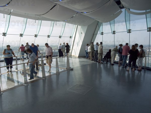 ENGLAND, Hampshire, Portsmouth, "Gunwharf Quays. The Spinnaker Tower. Interior view with visitors looking out of glass windows on the top observation deck, providing a 320° view of the city of Portsmouth, the Langstone and Portsmouth harbours, and a viewing distance of 37 kilometres (23 miles)"