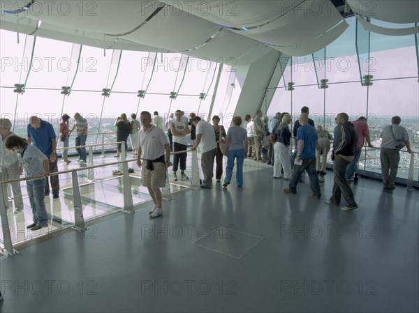 ENGLAND, Hampshire, Portsmouth, "Gunwharf Quays. The Spinnaker Tower. Interior view with visitors looking out of glass windows on the top observation deck, providing a 320° view of the city of Portsmouth, the Langstone and Portsmouth harbours, and a viewing distance of 37 kilometres (23 miles)"