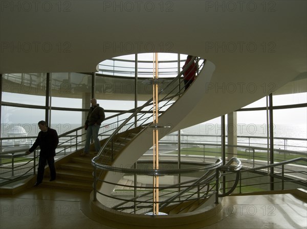 ENGLAND, East Sussex, Bexhill-on-Sea, The De La Warr Pavilion. Interior view of the helix staircase with visitors walking the steps