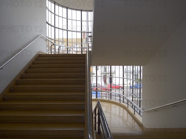 ENGLAND, East Sussex, Bexhill-on-Sea, "The De La Warr Pavilion. Interior view of the projecting staircase at the front of the building, white walls, polished orange gold terrazzo floors and steel framed windows "