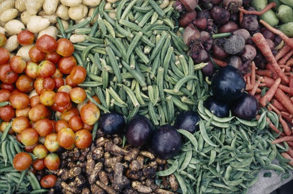INDIA, Madhya Pradesh, Gwalior, "Close cropped view of vegetables displayed on market stall including okra, aubergines, tomatoes, beetroot, potatoes and carrots."