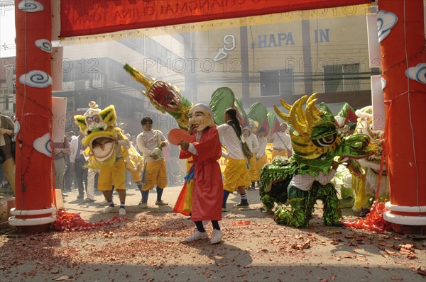 THAILAND, North, Chiang Mai, "Chinese New Year celebrations. Dwarf, lion dancers, dragon dancers and exploding firecrackers at the conclusion of the parade, Warorot Market area Chiang Mai's China Town, "
