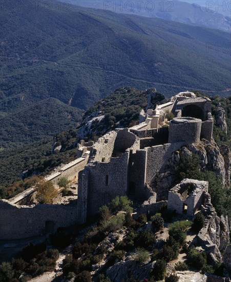 FRANCE, Languedoc-Roussillon, Aude, "Chateau Peyrepertuse.  Ruined medieval Cathar castle stronghold, lower section situated on steep rocky mountainside high above surrounding landscape."