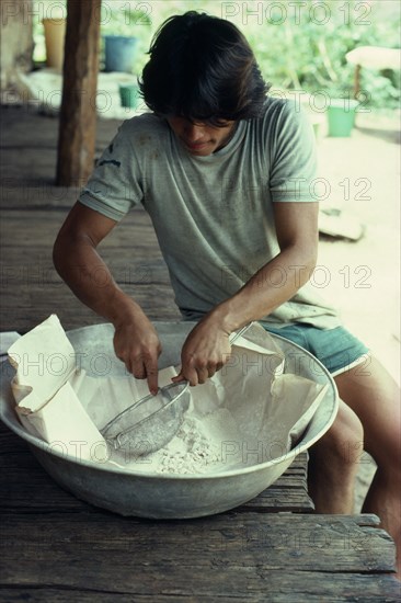 COLOMBIA, Vaupes, William half-Tukano Indian whose father runs this illegal cocaine lab. Sieves base cocaine before processing to final product