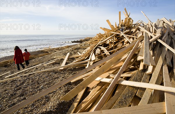 ENGLAND, West Sussex, Worthing, Timber washed up on the beach from the Greek registered Ice Princess which sank off the Dorset coast on 15th January 2008. Two women walk on the shoreline past the debris