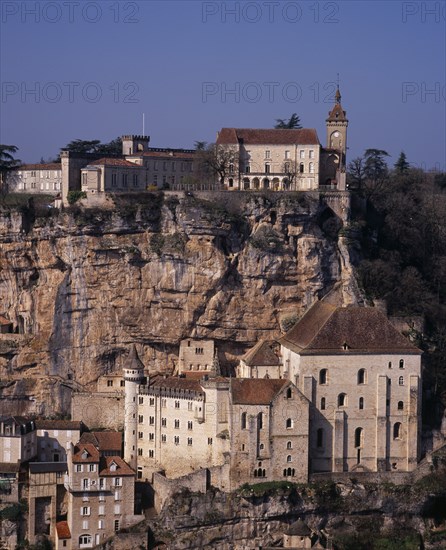 FRANCE, Midi-Pyrenees, Lot, Rocamadour.  Chateau on clifftop with 12th century Basilica of St-Sauveur on lower right and Museum of Sacred Art on left.