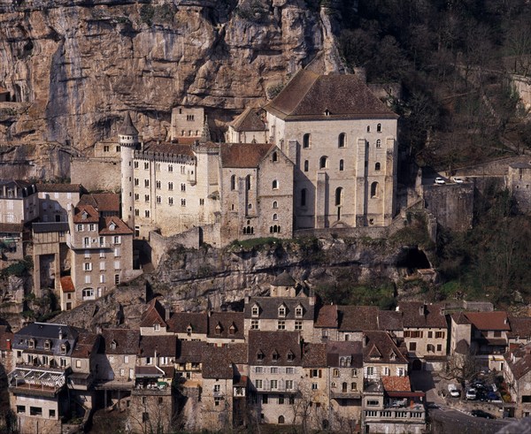 FRANCE, Midi-Pyrenees, Lot, Rocamadour.  Twelth century Basilica of St-Sauveur centre right and Museum of Sacred Art situated at base of cliff above cluster of old village buildings.