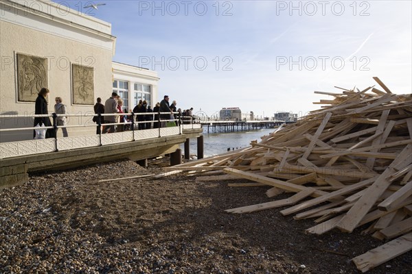 ENGLAND, West Sussex, Worthing, Timber washed up on the beach from the Greek registered Ice Princess which sank off the Dorset coast on 15th January 2008. Sightseers on the Pier look at the debris beside it