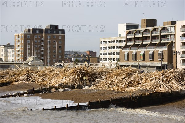 ENGLAND, West Sussex, Worthing, Timber washed up on the beach from the Greek registered Ice Princess which sank off the Dorset coast on 15th January 2008. Wood sits between groynes above the high water mark with seafront flats beyond