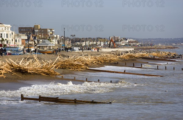 ENGLAND, West Sussex, Worthing, Timber washed up on the beach from the Greek registered Ice Princess which sank off the Dorset coast on 15th January 2008. Wood sits above the high water mark beyond the groynes in front of seafront buildings