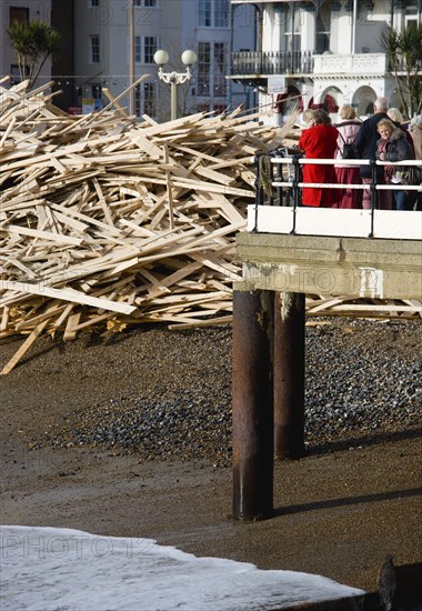 ENGLAND, West Sussex, Worthing, Timber washed up on the beach from the Greek registered Ice Princess which sank off the Dorset coast on 15th January 2008. Sightseers on the pier look at the debris beside it