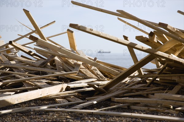 ENGLAND, West Sussex, Worthing, Timber washed up on the beach from the Greek registered Ice Princess which sank off the Dorset coast on 15th January 2008. A cargo ship passes in the distance on the horizon