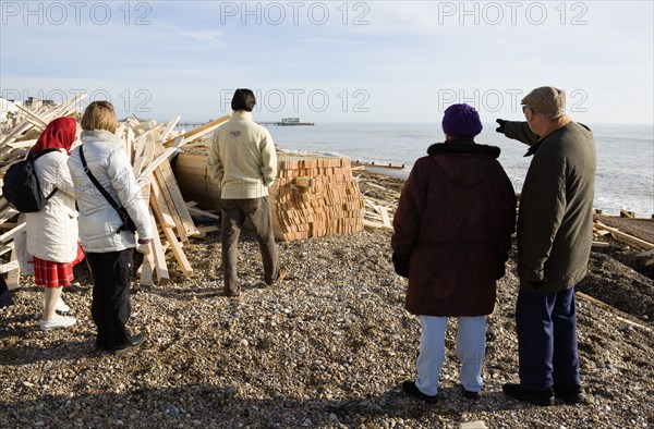 ENGLAND, West Sussex, Worthing, Timber washed up on the beach from the Greek registered Ice Princess which sank off the Dorset coast on 15th January 2008. Five people stand amongst the debris with Worthing Pier in the distance