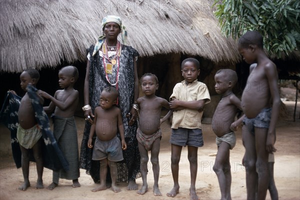 SENEGAL, People, Village queen standing with group of children.  She is believed to be a witch and endowed with healing and other spiritual powers.